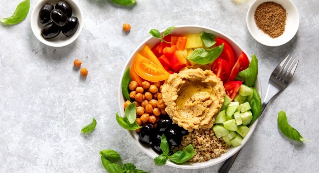 Plate of Hummus, cucumbers, tomatoes, chic peas, olives